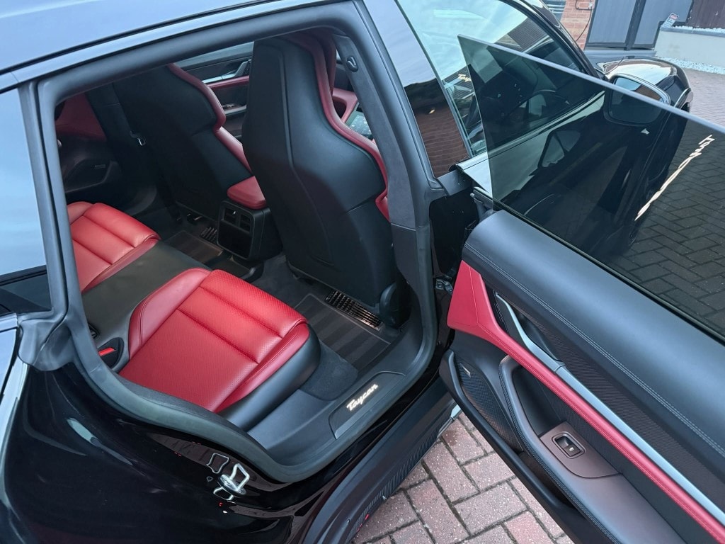 Porsche Taycan rear interior — red leather seats cleaned and treated after Signature Valet
