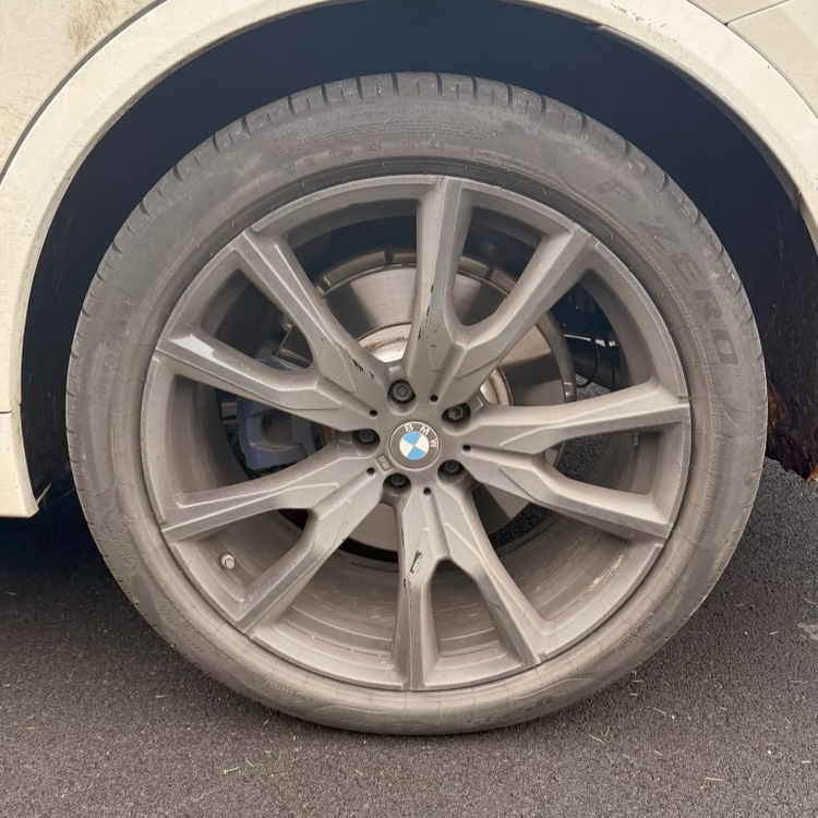 BMW alloy wheel before — heavily coated in brake dust and grime, dull grey finish