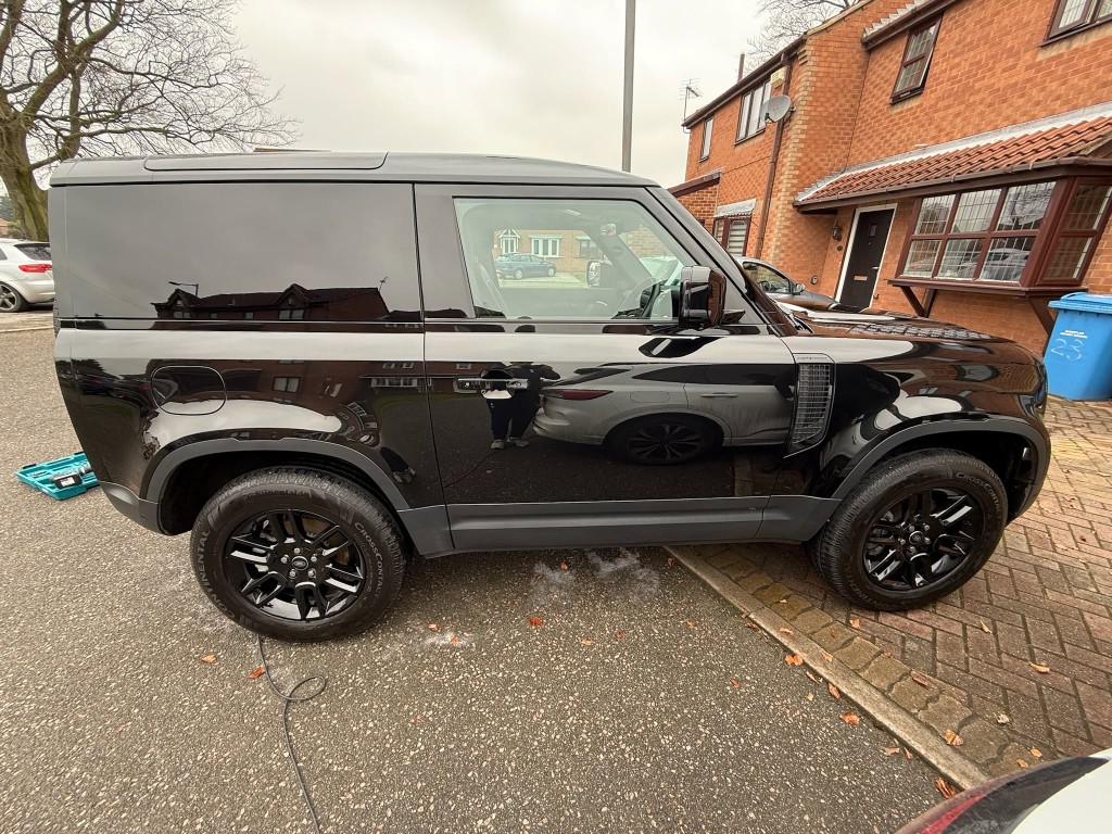 Defender 90 after — deep gloss black finish restored, spotless side panels