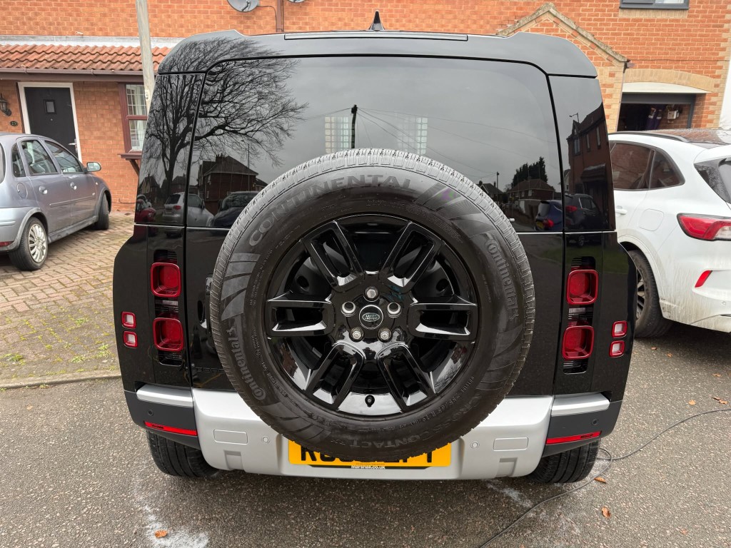 Land Rover Defender exterior after — deep gloss black finish, tyre dressed, showroom clean