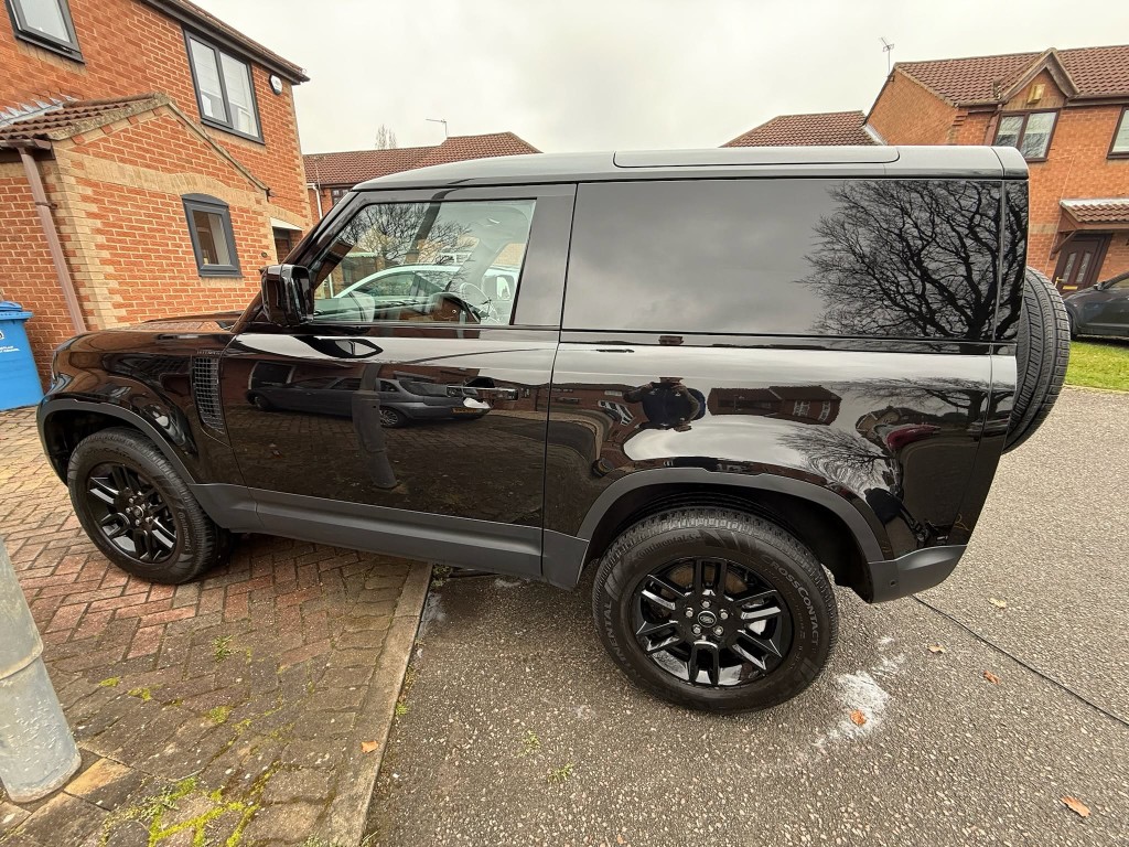 Land Rover Defender 90 after — deep gloss black finish, tyres dressed, mirror-like reflection