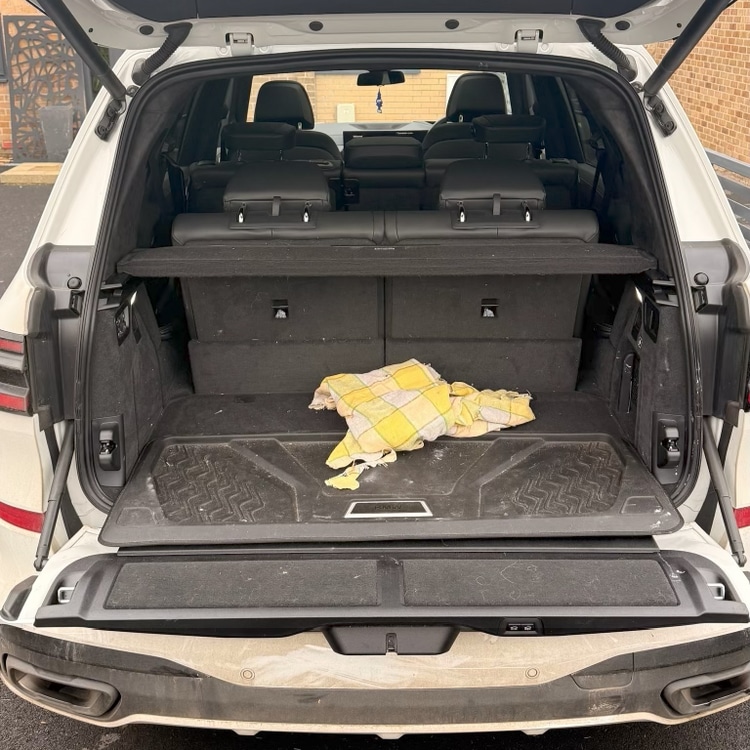 Large SUV boot before — dirty load mat, old cloth and debris throughout